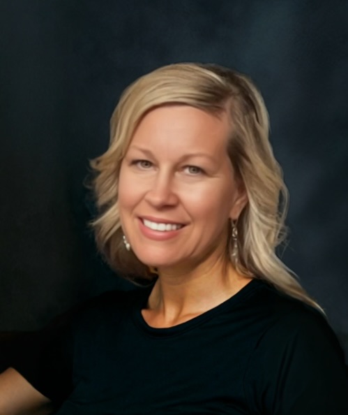 Woman smiling at the camera against a dark background